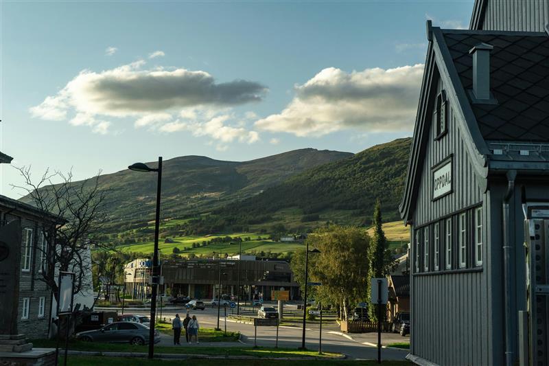 Sommerbilde med Oppdal stasjon i forgrunnen og Vangslia i bakgrunnen.